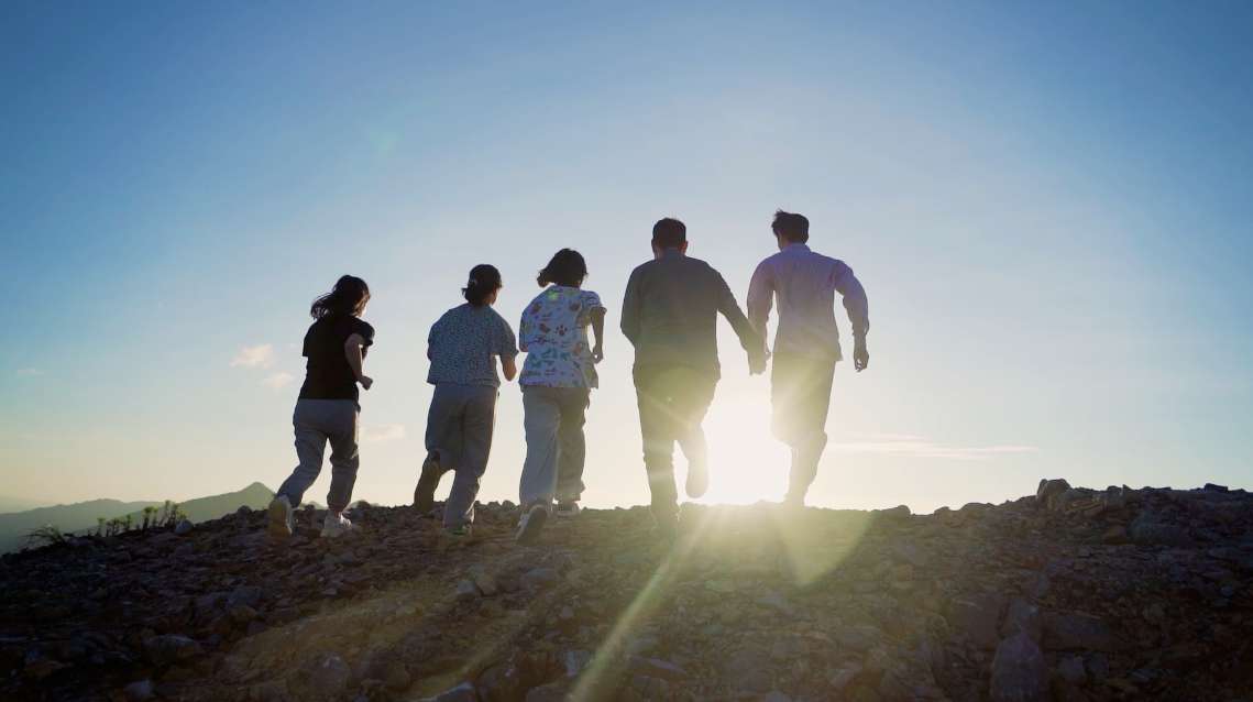 团队协作手搭手加油大气成功登顶攀登高峰