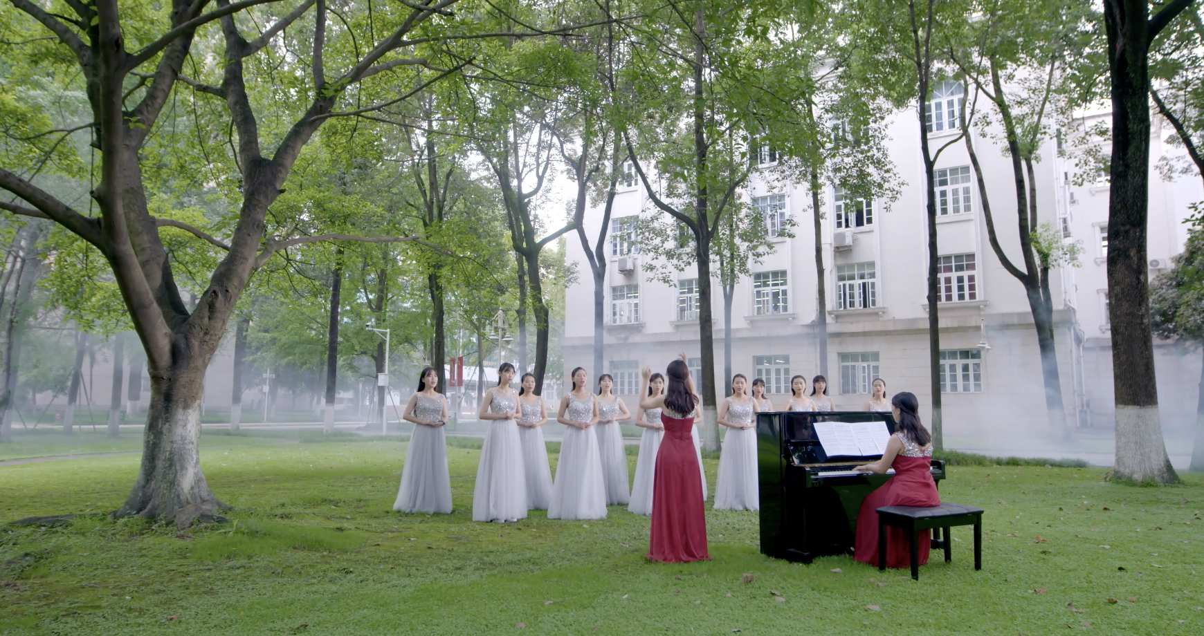 女孩在树荫下看书图书馆的莘莘学子排练演唱表演