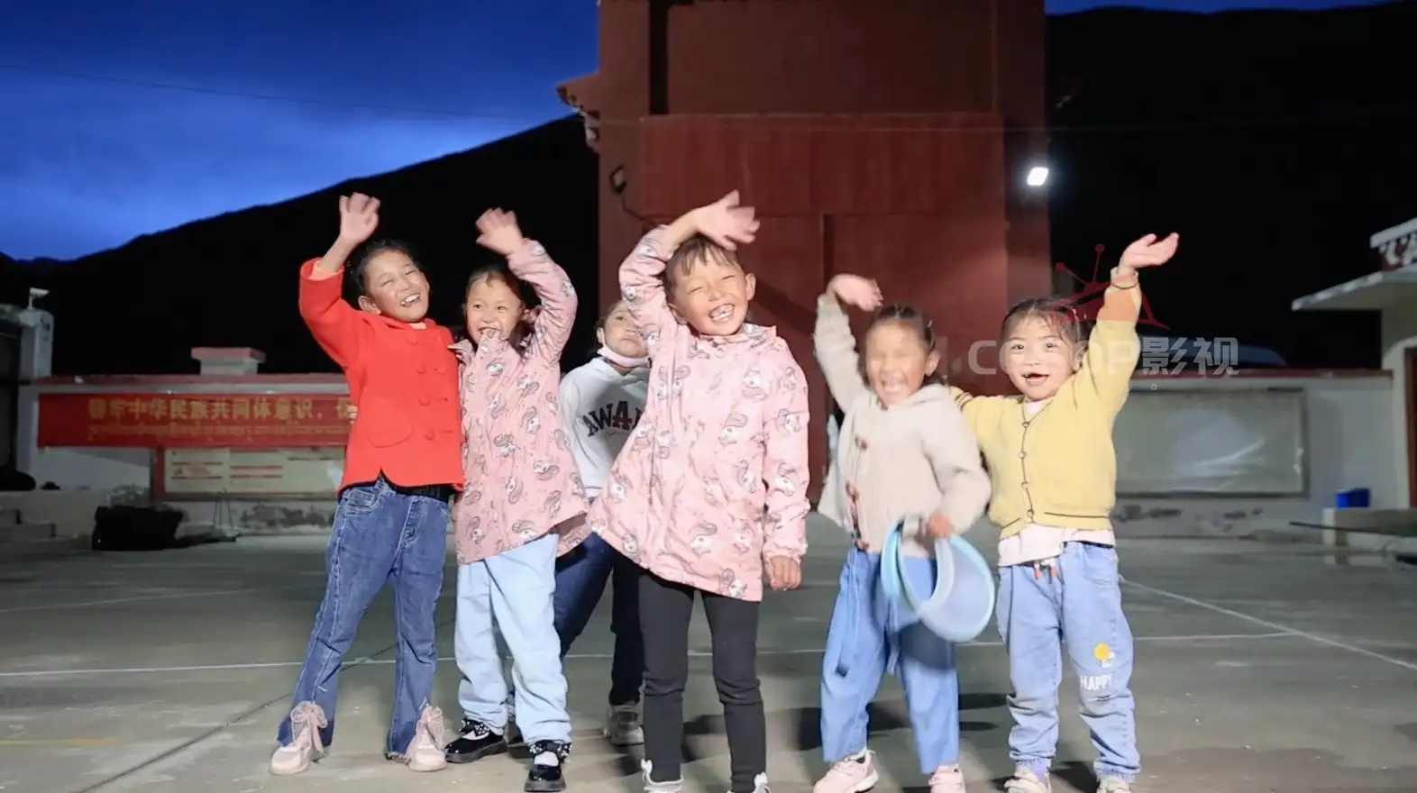 一群藏族小孩子挥手笑脸